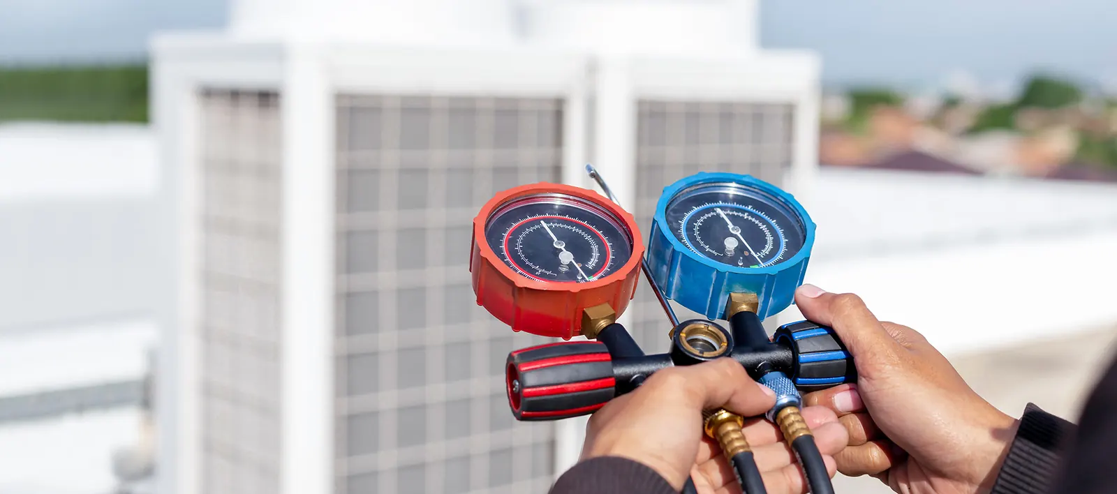 Comfort Makers technician checking refrigerant pressure on an AC unit